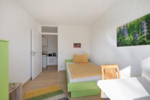 a small room with a bed and a table at Birkethof Gartenblick in Grimoldsried