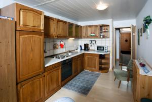 a kitchen with wooden cabinets and a stove top oven at Ferienhof Rosenwarft in Pellworm