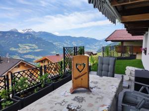 a balcony with a table with a view of mountains at Ferienwohnung Zillertalblick in Stummerberg