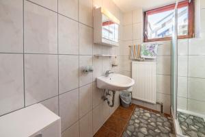 a white bathroom with a sink and a shower at Ferienwohnung Zillertalblick in Stummerberg +29 photos