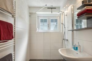 a white bathroom with a sink and a window at Ferienwohnung am Waldrand in Alpirsbach +24 photos