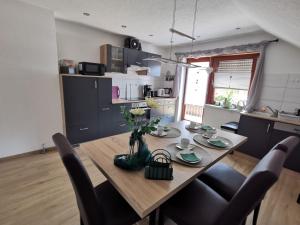 a dining room table with a vase of flowers on it at Ferienwohnung Schöner in Oberharmersbach