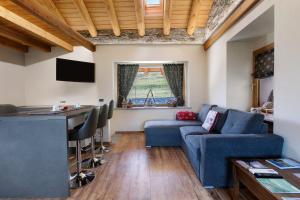 a living room with a blue couch and a table at Alpine A-S in Aymavilles +17 photos