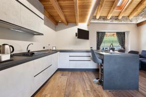 a kitchen with white cabinets and a black counter top at Alpine A-S in Aymavilles