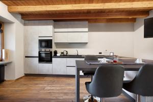 a kitchen with white cabinets and a table and chairs at Alpine A-S in Aymavilles