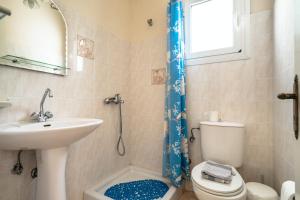 a bathroom with a sink and a toilet and a window at Anemona studio B in Kefallonia +12 photos