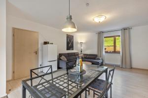a dining room and living room with a glass table at Hof Helmenhube 2 in Oberzent