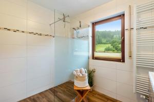 a bathroom with white tile walls and a window at Hof Helmenhube 2 in Oberzent +17 photos