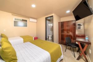 ein Hotelzimmer mit zwei Betten und einem Flachbildfernseher in der Unterkunft Hotel Boutique Las Campanas in Tlaxcala de Xicohténcatl