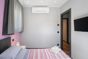 a bedroom with a bed and a tv on the wall at Agriturismo il Borgo - Lavanda in Villanova dʼAlbenga
