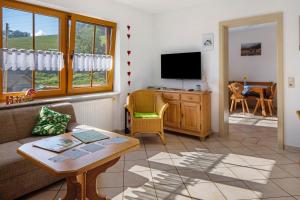 a living room with a couch and a tv at Hinterbauernhof Fewo Pferdeglück in Stegen