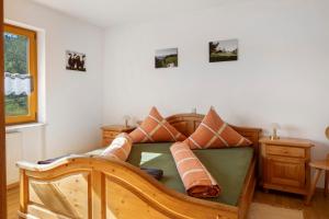 a bedroom with a wooden bed with pillows on it at Hinterbauernhof Fewo Pferdeglück in Stegen