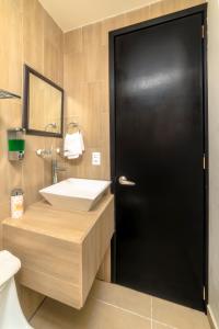 ein Badezimmer mit Waschbecken und schwarzer Tür in der Unterkunft Hotel Boutique Las Campanas in Tlaxcala de Xicohténcatl + 28 Fotos