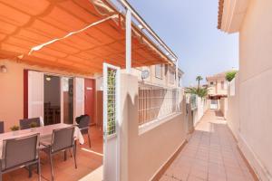a patio with a wooden pergola and a table and chairs at Puerta Marina Costa de la Luz in La Redondela