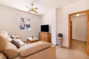 a living room with a couch and a tv at Puerta Marina Costa de la Luz in La Redondela