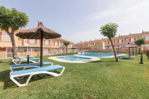 a pool with lounge chairs and an umbrella at Puerta Marina Costa de la Luz in La Redondela