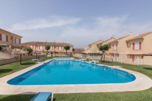 a swimming pool in a yard with houses at Puerta Marina Costa de la Luz in La Redondela