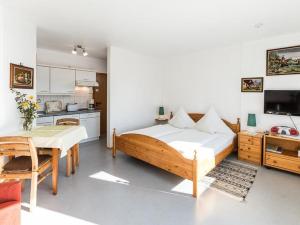 a bedroom with a bed and a table and a kitchen at Haus Fanjak in Uhldingen-Mühlhofen