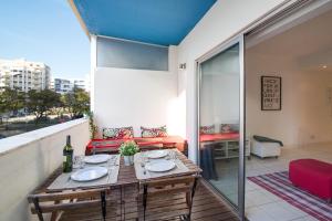 a dining table on a balcony with a view of the city at Modern Apartment by the Sea in Quarteira