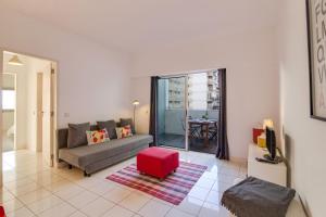 a living room with a couch and a red stool at Modern Apartment by the Sea in Quarteira