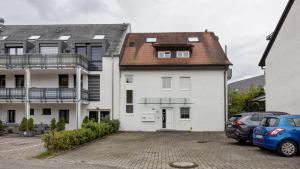 a white building with a brown roof at Ferienwohnung Heidegarten in Radolfzell am Bodensee