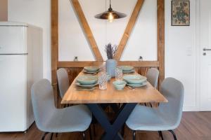 a dining room table with chairs and a white refrigerator at Ferienwohnung Am Mehlberg in Hinterzarten