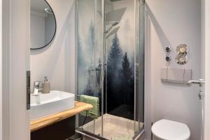 a bathroom with a glass shower and a sink at Ferienwohnung Am Mehlberg in Hinterzarten +21 photos