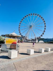 a ferris wheel with a person walking in front of it at Suite GrandLarge in Berck-sur-Mer