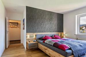 ein Schlafzimmer mit einem großen Bett und rosa Kissen in der Unterkunft Sauerlandrefugium in Medebach