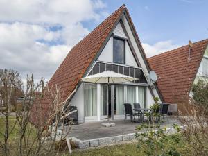 a house with a pitched roof with a patio at Wikinger 74 in Immenstaad am Bodensee