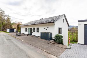 ein weißes Haus am Straßenrand in der Unterkunft Sauerlandrefugium in Medebach