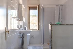 a white bathroom with a sink and a shower at Villa Tre 's' in Montallegro