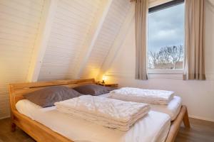two beds in a room with a window at Wikinger 74 in Immenstaad am Bodensee