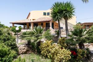 a house with palm trees in front of it at Villa Tre 's' in Montallegro