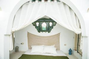 a bedroom with a bed with a canopy at Menzel LellaMina in Houmt Souk +21 photos