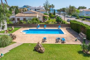a swimming pool in a yard with chairs and a house at Veleta ll in Pollença