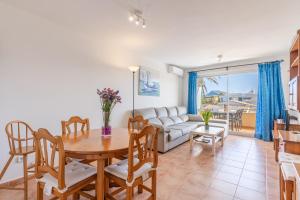 a living room with a table and chairs and a couch at Veleta ll in Pollença