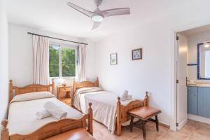 a bedroom with three beds and a ceiling fan at Veleta ll in Pollença