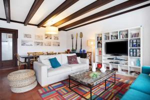 a living room with a white couch and a tv at São Martinho All The Best in São Martinho do Porto