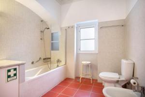 a bathroom with a toilet and a tub and a sink at São Martinho All The Best in São Martinho do Porto +30 photos