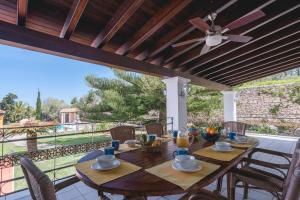 a wooden table on a patio with a ceiling fan at Can Joan Vich I in Santa Eularia des Riu