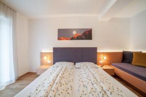 a bedroom with a bed and a couch at Haus Hohenrain Ferienwohnung 1 in Schenna +23 photos