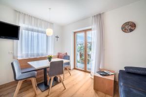 a living room with a dining room table and a couch at Haus Hohenrain Ferienwohnung 1 in Schenna
