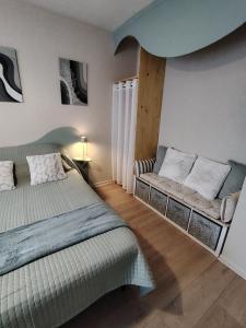 a bedroom with a bed and a couch in it at L échappée verte in Gien