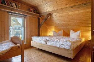 a bedroom with a bed in a wooden room at Ferienhaus Am Darß - Leuchtturm in Pruchten