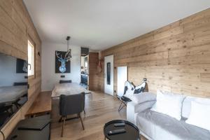 a living room with a white couch and a wooden wall at Le Chappart - Carroz d'Arâches in Arâches-la-Frasse