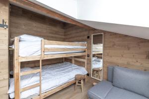 a bunk bed room with two bunk beds and a couch at Le Chappart - Carroz d'Arâches in Arâches-la-Frasse