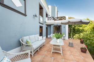 a patio with a couch and an umbrella at Caldera de Taburiente Rural in El Paso