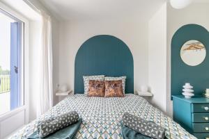 a bedroom with a bed with a blue headboard at La maison des chevaux in Saint-Vran