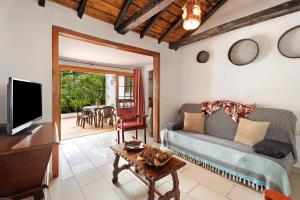 a living room with a couch and a tv and a table at Casa Rural Medina 1 in Agulo